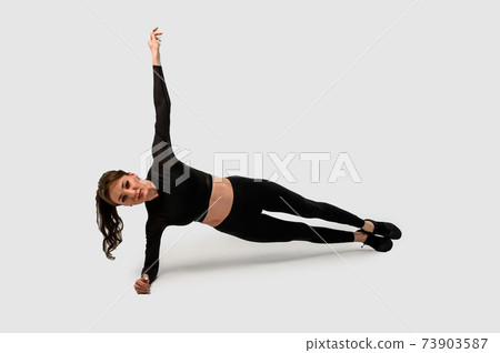 Side view of beautiful young sports lady doing plank in studio. Copy space Side view of beautiful young sports lady doing plank in studio. Copy space 73903587
