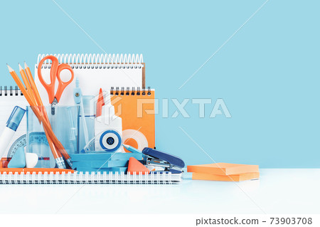 Group of office and school yellow orange and light blue stationery on desk 73903708
