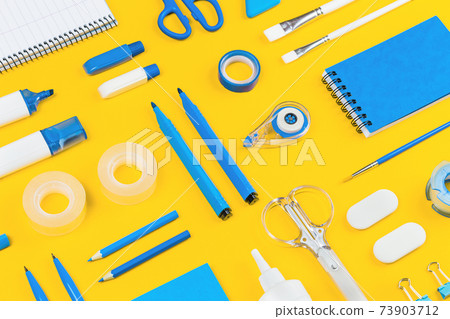 Assorted office and school white and blue stationery on yellow 73903712