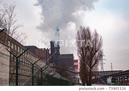 Industrial zone. Air pollution by smoke coming out of two factory chimneys.  73905326