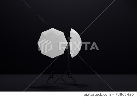 Photography studio lighting stand with flash and umbrella isolated on black 73905480