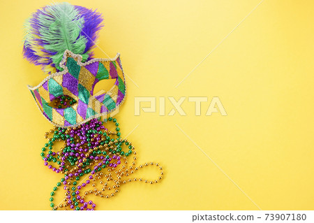 Mardi gras or carnival mask with beads on yellow background. Venetian mask. 73907180