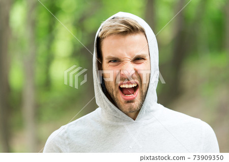 Man with bristle on shouting face, nature background 73909350