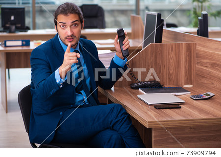 Young male employee working in the office Young male employee working in the office 73909794