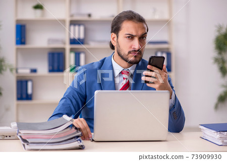 Young male employee working in the office Young male employee working in the office 73909930