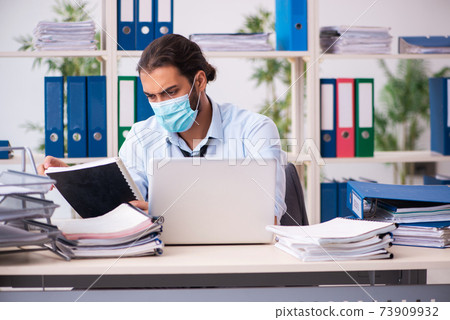 Young male employee working in the office during pandemic Young male employee working in the office during pandemic 73909932