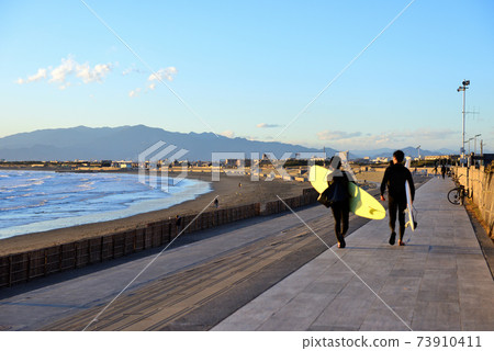 Two surfers walking along the Shonan Beach promenade Two surfers walking along the Shonan Beach promenade 73910411