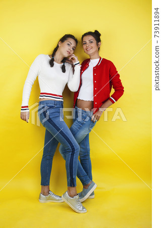lifestyle people concept: two pretty young school teenage girls having fun happy smiling on yellow background 73911894