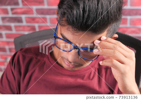 sad young man sits alone on a chair sad young man sits alone on a chair 73913136