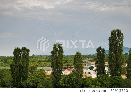 Houses at the foot of Caucasus Mountain range with peak snow background in Gebele, Gabala Azerbaijan  73913760