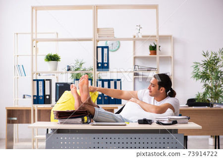 Young male employee looking after newborn at workplace Young male employee looking after newborn at workplace 73914722