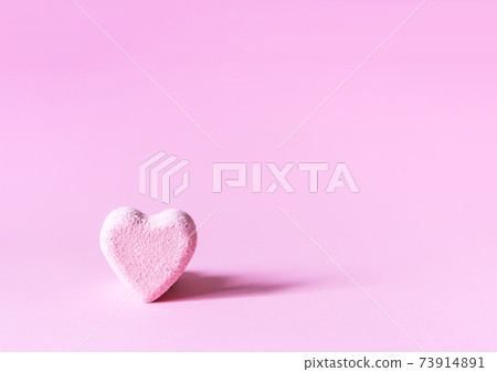 Pink small bath bomb in the shape of heart on soft pastel background Pink small bath bomb in the shape of heart on soft pastel background 73914891
