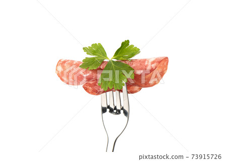 Three thin slices of cooked smoked sausage with parsley leaf. 73915726