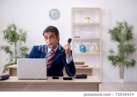 Young male employee sitting in the office 73916424