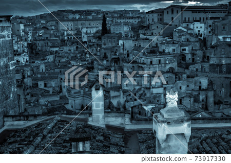 Evening view of the city of Matera. Old buildings in the Sassi di Matera. Italy. Evening view of the city of Matera. Old buildings in the Sassi di Matera. Italy. 73917330