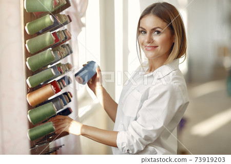 Woman standing in the factory with a thread 73919203