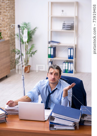 Young male employee suffering at workplace Young male employee suffering at workplace 73919408