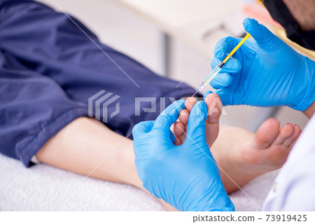 Podiatrist treating feet during procedure Podiatrist treating feet during procedure 73919425
