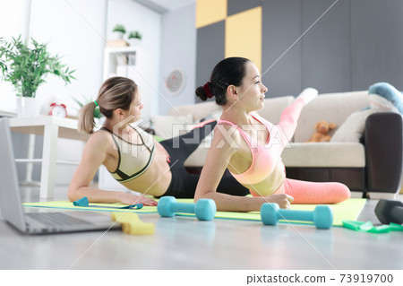 Women doing sports exercises on floor at home Women doing sports exercises on floor at home 73919700