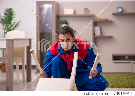 Young male contractor repairing chair indoors 73919749