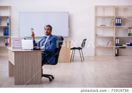 Young male employee and too much work in the office 73919786