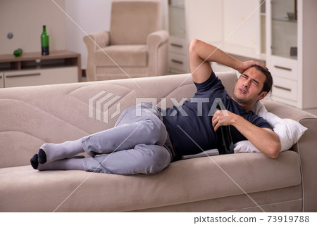 Young male alcoholic suffering at home Young male alcoholic suffering at home 73919788