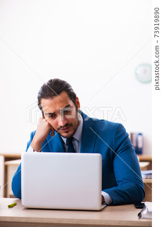Young male employee and too many work in the office Young male employee and too many work in the office 73919890
