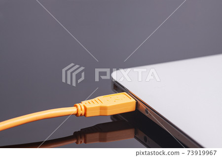 laptop with USB orange cable laptop with USB orange cable 73919967