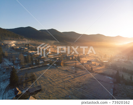 Mountain Village in the Morning. Aerial Shot of Majestic Sunrise in a Valley at Foggy Morning Mountains Landscape. Fir Tops and Cozy Houses in Carpathians, Tatariv, Ukraine, Europe 73920162