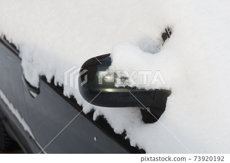 The mirror of the car is covered with snow. The mirror of the car is covered with snow. 73920192