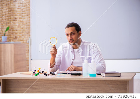 Young male chemistry teacher in the classroom Young male chemistry teacher in the classroom 73920415