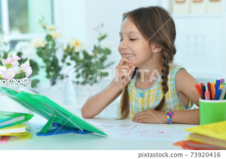 Portrait of cute little girl studying at home 73920416