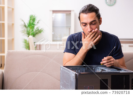 Young man repairing computer at home Young man repairing computer at home 73920718