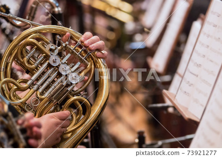 Horn professional player with symphony orchestra performing Horn professional player with symphony orchestra performing 73921277
