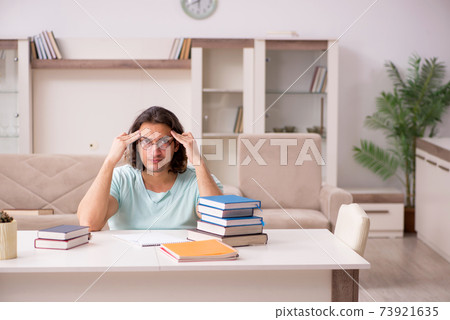 Young male student preparing for exams at home Young male student preparing for exams at home 73921635