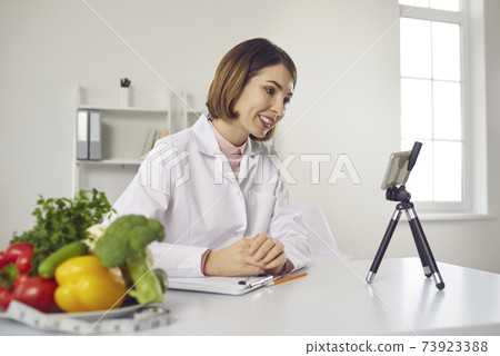 Nutritionist at the clinic video calling patient for online consultation on healthy diet 73923388