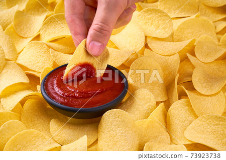 man holds potato chips in hands, closeup photo with selective focus. 73923738