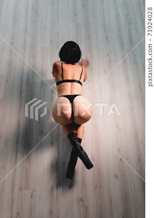 Sexy slender brunette with perfect shape of buttocks posing on a floor Sexy slender brunette with perfect shape of buttocks posing on a floor 73924028