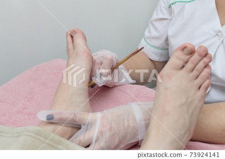 Relaxing massage on the foot in spa salon - indoors. Relaxing massage on the foot in spa salon - indoors. 73924141