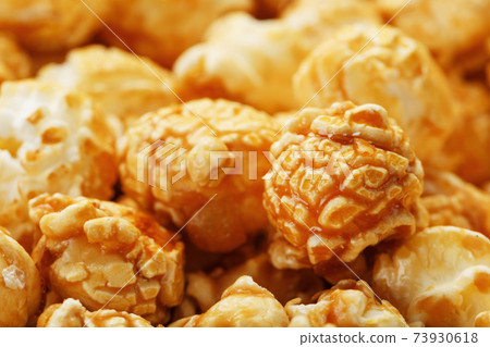 Popcorn in caramel glaze macro as a background. Popcorn in caramel glaze macro as a background. 73930618