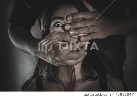 A man who covers his mouth women with his hand Human trafficking concept Violence victims 73931047