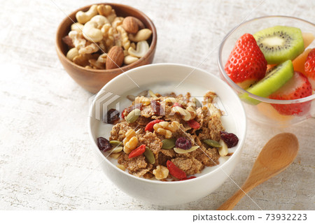 Breakfast of yogurt-poured cereal, fruits and nuts Breakfast of yogurt-poured cereal, fruits and nuts 73932223