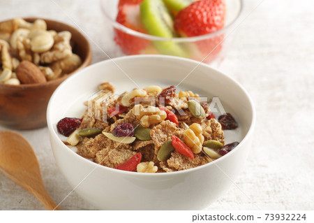 Breakfast of yogurt-poured cereal, fruits and nuts 73932224