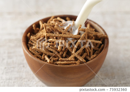 Breakfast cereals and flakes pouring milk 73932360