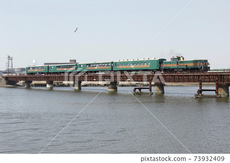 Kushiro Shitsugen Norokko crossing the Kushiro River railway bridge 73932409