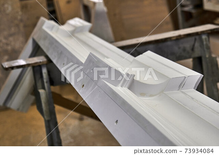 Joinery. Crown molding of a classic wardrobe. Production of wood furniture. Furniture manufacture. Close-up Joinery. Crown molding of a classic wardrobe. Production of wood furniture. Furniture manufacture. Close-up 73934084