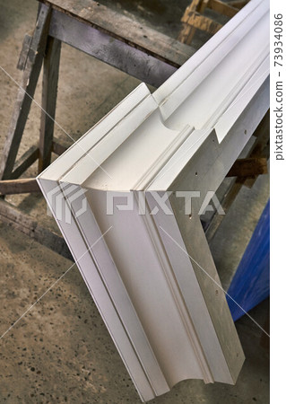 Joinery. Crown molding of a classic wardrobe. Production of wood furniture. Furniture manufacture. Close-up Joinery. Crown molding of a classic wardrobe. Production of wood furniture. Furniture manufacture. Close-up 73934086