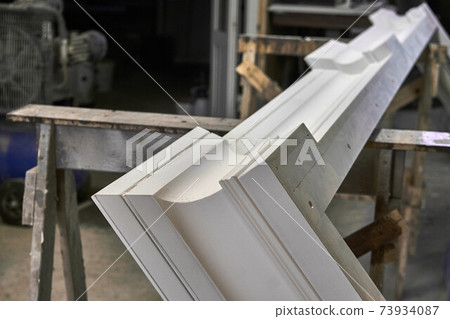 Joinery. Crown molding of a classic wardrobe. Production of wood furniture. Furniture manufacture. Close-up 73934087