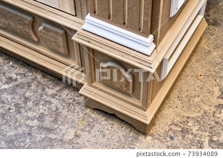Joinery. Mdf cabinet carcass with moldings and carved base. Wooden furniture manufacturing process 73934089