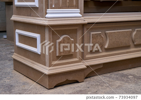 Joinery. Mdf cabinet carcass with moldings and carved base. Wooden furniture manufacturing process Joinery. Mdf cabinet carcass with moldings and carved base. Wooden furniture manufacturing process 73934097